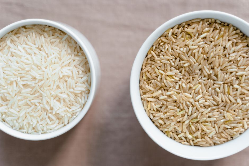 Vista superior de arroz blanco y arroz integral crudos en tazones